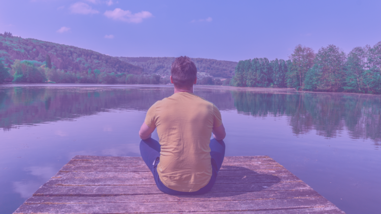 Joven de espaldas mediatndo frente a un lago